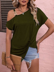 Women's off-shoulder blouse in army green, styled with a chic silhouette and accessorized with denim shorts and a clutch.