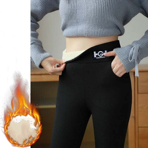 Woman wearing black cashmere leggings and grey sweater indoors.