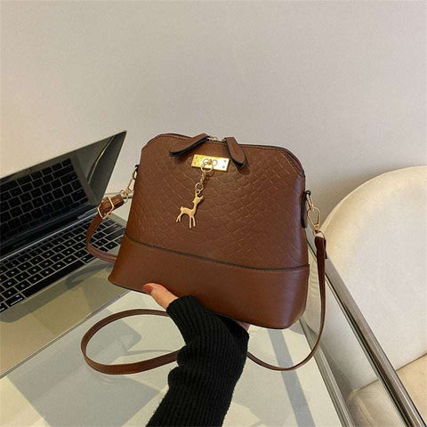 Womens Mini Portable Handbag in brown PU leather with telescopic handle, showcasing compact and chic design on a table.