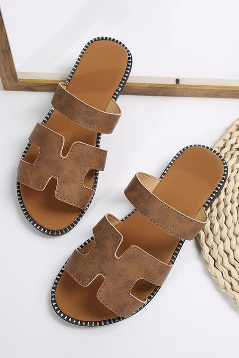 Black leather H band slides with cushioned footbed on a white background.