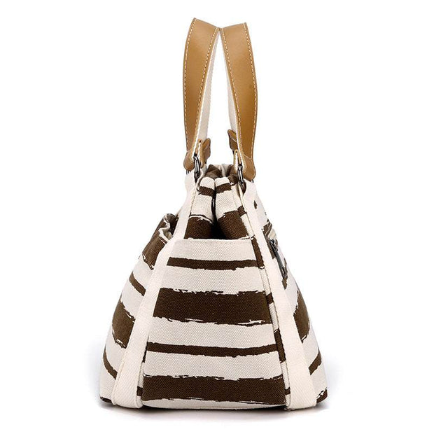 Canvas One-Shoulder Tote with stripes and brown handles, spacious and stylish accessory.