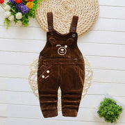 Children brown overalls with cartoon bear design, adjustable straps, and multiple pockets, on a decorative background.