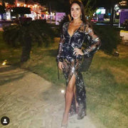 Elegant woman wearing a stylish black lace dress with intricate sequins and high slit, suited for formal occasions.