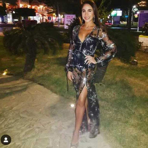 Elegant woman wearing a stylish black lace dress with intricate sequins and high slit, suited for formal occasions.