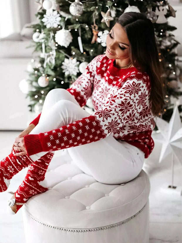 woman wearing red and white snowflake pattern long sleeve sweater sitting by decorated Christmas tree