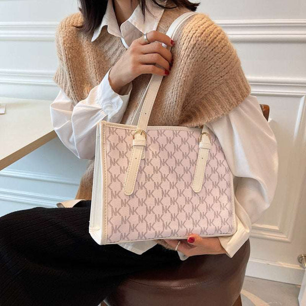 Large Capacity Handbag with monogram design in cream and beige shades.