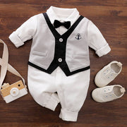 Baby Gentleman Jumpsuit with collar, faux vest, bowtie, and button-down front displayed with matching shoes.
