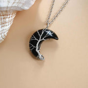 Moon Tree Of Life Necklace with black crescent pendant and silver tree design on chain.