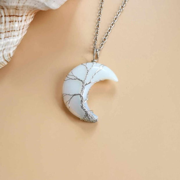 Moon Tree Of Life Necklace with tree of life pendant, celestial moon accents, crystal material, and adjustable chain.