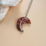 Moon Tree Of Life Necklace with crescent-shaped red stone pendant featuring an intricate tree design on water wave chain.