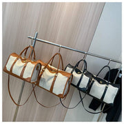 Large capacity purses in black and brown on a clothing rack.
