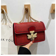 Red chain shoulder bag with textured design and gold accents.