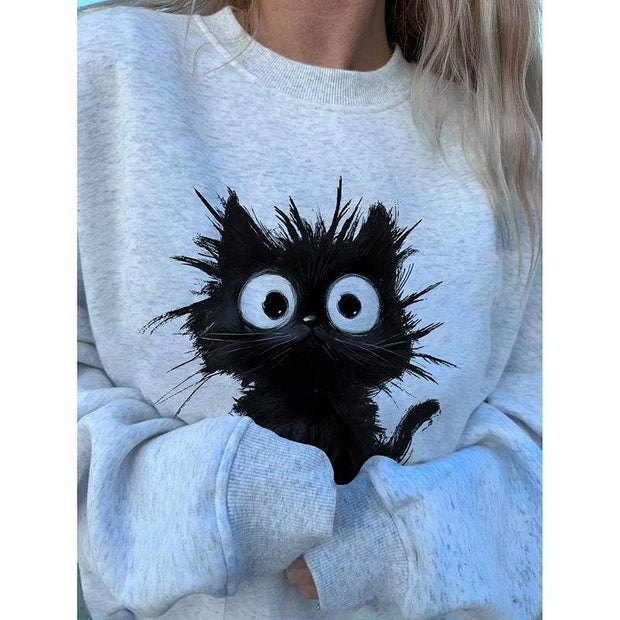 Woman wearing light gray kitten graphic sweatshirt with cartoon black kitten illustration on front