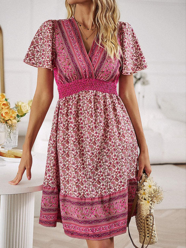 Floral smocked waist mini dress with vibrant floral print and short sleeves.