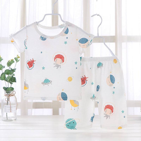 Youth pajama set with playful space-themed design hanging on hangers.