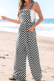 Checkered print pocketed wide leg jumpsuit on beach.