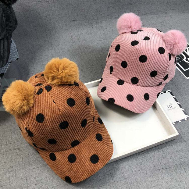 Polka dot ball peaked hats with dual pom-poms in pink and ginger colors.