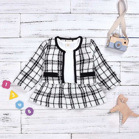 Two Piece Children Wind Suit in black and white plaid pattern on a wooden background with toys.