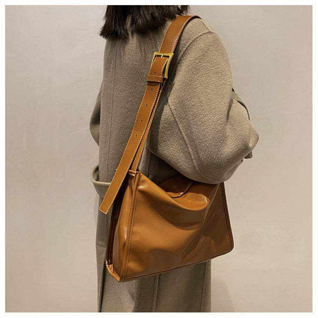 Retro Crossbody Commuter Tote in brown worn by a person, showcasing adjustable strap and sleek design.