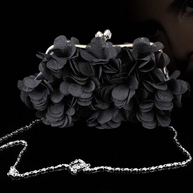 Elegant black bridal clutch adorned with floral details and silver chain.