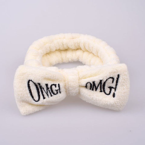 Soft coral velvet butterfly hair band with "OMG" text, chic and comfortable accessory.
