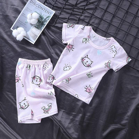 Youth pajama set with playful cat and rainbow print, soft fabric, short-sleeve top, and matching shorts.