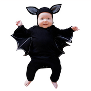 Baby wearing Batman Baby Onesie with bat wings and ear hood.