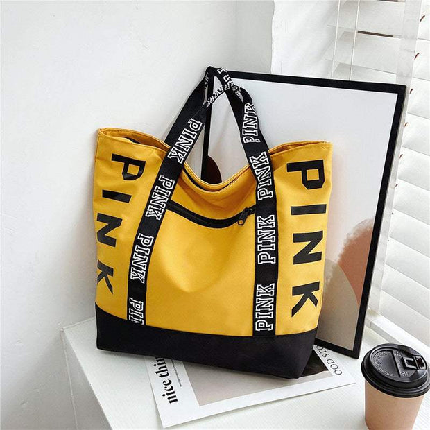 Large Capacity Handbag in yellow with "PINK" text, versatile and stylish design.