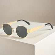 Metal Oval Vintage Sunglasses with gold frame and dark lenses on beige background.
