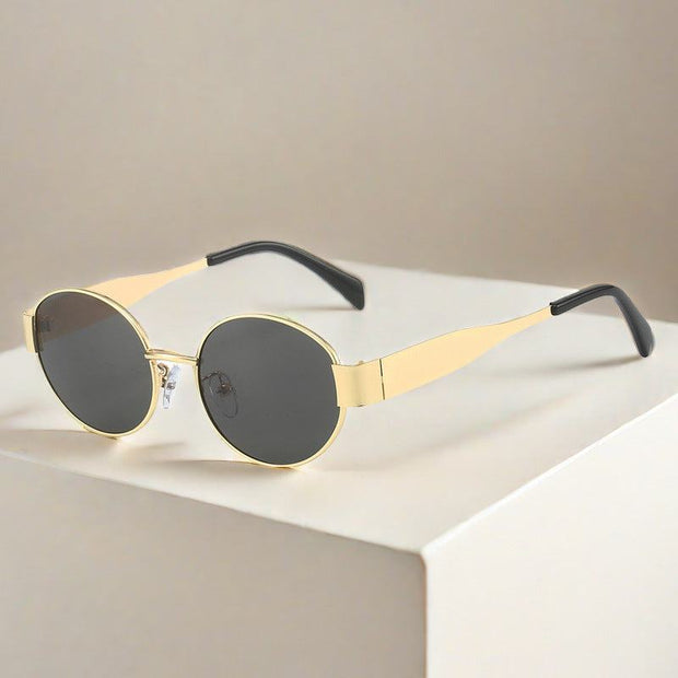 Metal Oval Vintage Sunglasses with gold frame and dark lenses on beige background.