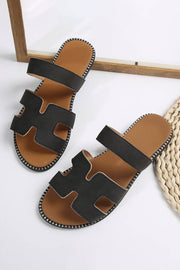 Black leather H band slides with cushioned footbed on white background.