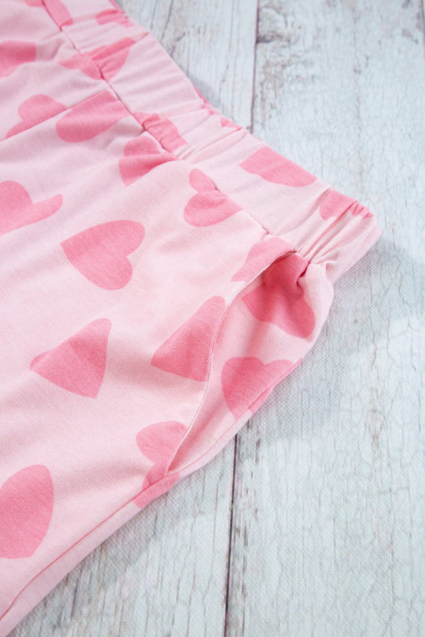 Pink heart print on soft fabric loungewear shorts, featuring an elastic waist for comfort.