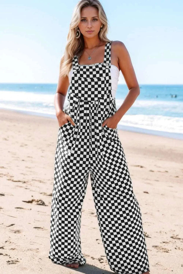 Checkered print wide leg jumpsuit with pockets, worn at the beach.