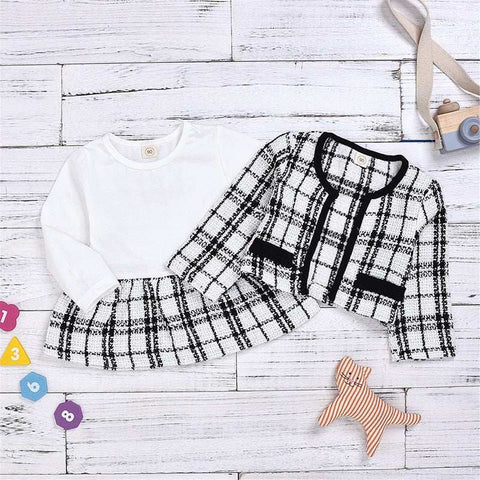 Two Piece Children Wind Suit in plaid pattern with matching jacket and pants on wooden background.