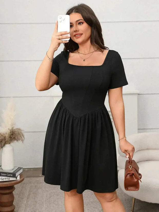 Plus size square-neck short-sleeve mini dress in black, worn by a person taking a selfie, paired with a brown handbag.