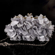 Elegant bridal clutch with floral detailing and chain strap, ideal for weddings.