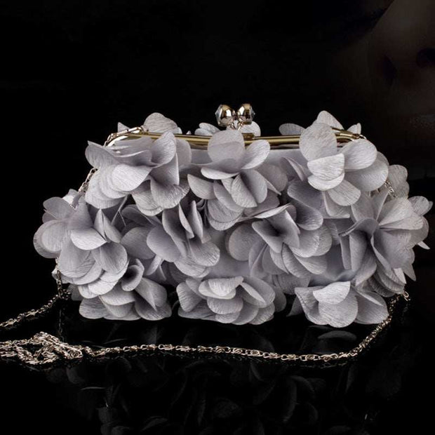 Elegant bridal clutch with floral detailing and chain strap, ideal for weddings.