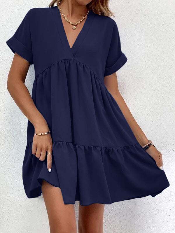 Short-sleeved V-neck dress with flowy skirt and elegant silhouette.