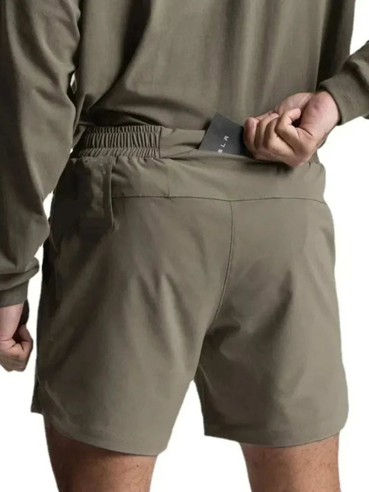 Men's elastic waist active shorts in olive green showing secure fit and stretchable design.