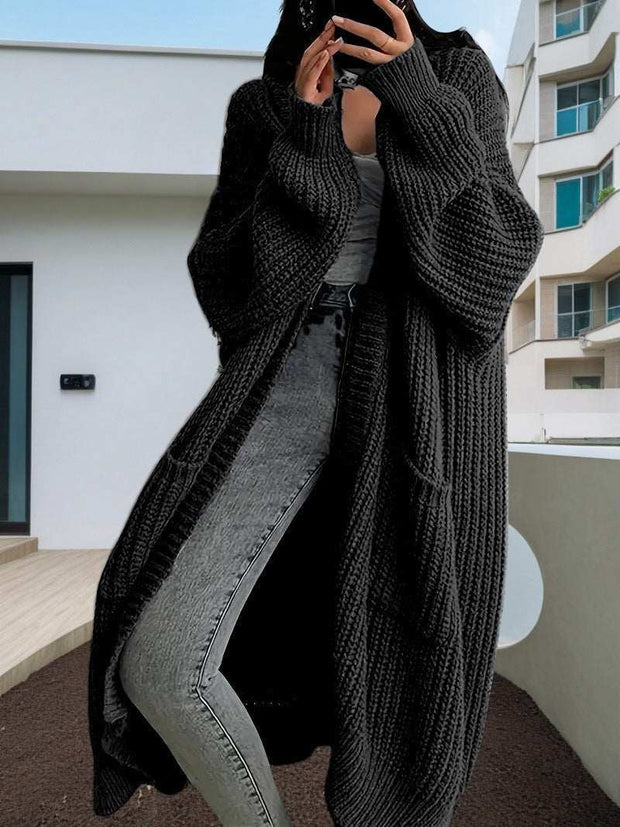 black long sleeve long knitted cardigan with oversized fit and open front worn with grey jeans and black top outdoors