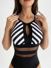 Woman wearing black and white striped mesh backless swimsuit with cutout detail and sheer mesh panels at the waist