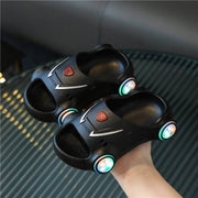 Kids glowing slippers in black with LED lights illuminating the soles, designed for comfort and fun.