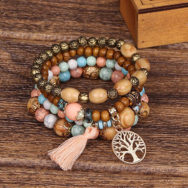 Boho Wooden Stretch Bracelet with colorful beads and tree charm on a wooden surface.