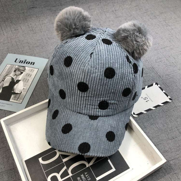 Ball Peaked Hat with double ball design, corduroy material, dot pattern, and adjustable strap for sun protection.