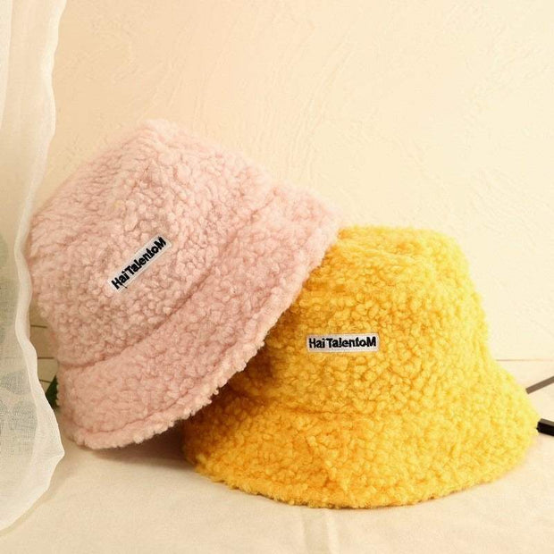 Lambswool Female Fishing Cap in pastel pink and yellow with embroidered text, ideal for outdoor activities.