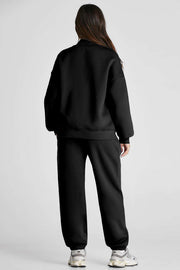 Black two-piece Quarter Zip Top and Pants Set, featuring long sleeves, chic zip neckline, and pocketed pants for a cozy, fashionable look.