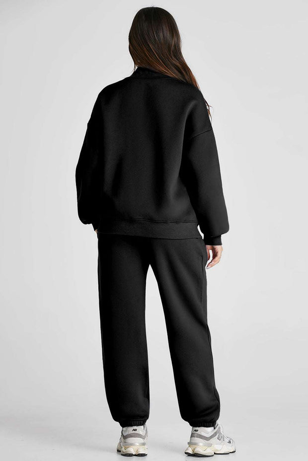 Black two-piece Quarter Zip Top and Pants Set, featuring long sleeves, chic zip neckline, and pocketed pants for a cozy, fashionable look.