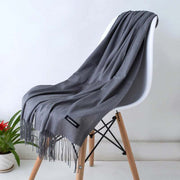 Elegant designer scarf shawl draped on chair, showcasing its versatile and luxurious design.