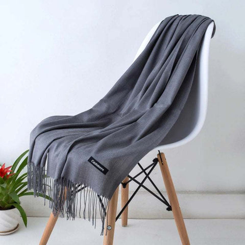 Elegant designer scarf shawl draped on chair, showcasing its versatile and luxurious design.