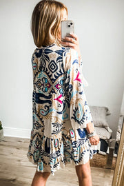 White Boho Print Mini Dress with whimsical design and ruffled hem.